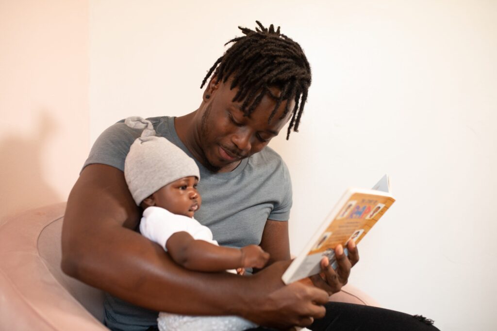 A dad reading a book to his baby