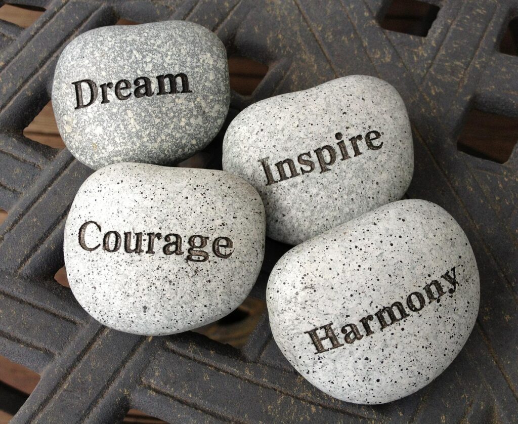 Painted stones that read Dream, Inspire, Courage and Harmony