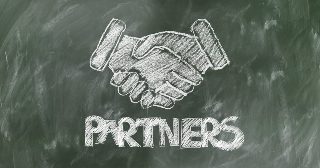 Chalkboard drawing of a handshake with the word Partners