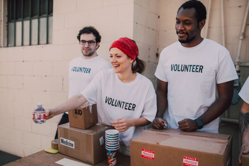Three volunteers sorting donated goods at a community drive